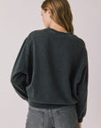 Back view of woman wearing Chaser’s Red Hearts Black Mineral Wash Long Sleeve on a light pink background