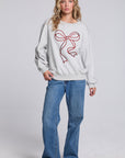 Model wearing Chaser's Merry Bow Pullover in Heather Grey with oversized red bow artwork, full-body view