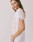 Side view of woman wearing Chaser’s The Beatles Strawberry Fields Forever White Tee on a plain background