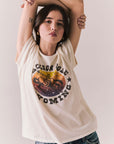 Front view of model wearing the Jackson Hole Sunset Tee in white with scenic Western graphic with graphic design on a plain background
