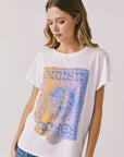 Front view of woman wearing Chaser’s white Guns N’ Roses World Tour Tee with colorful tour graphic (licensed band collaboration) on a plain background