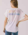 Back view of woman wearing Chaser’s white Guns N’ Roses World Tour Tee with “Appetite for Destruction Tour 1988” text (licensed band collaboration) on a plain background