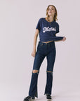 Full body view of the Chaser Merci Heart Tee styled with dark wash denim jeans on a plain background