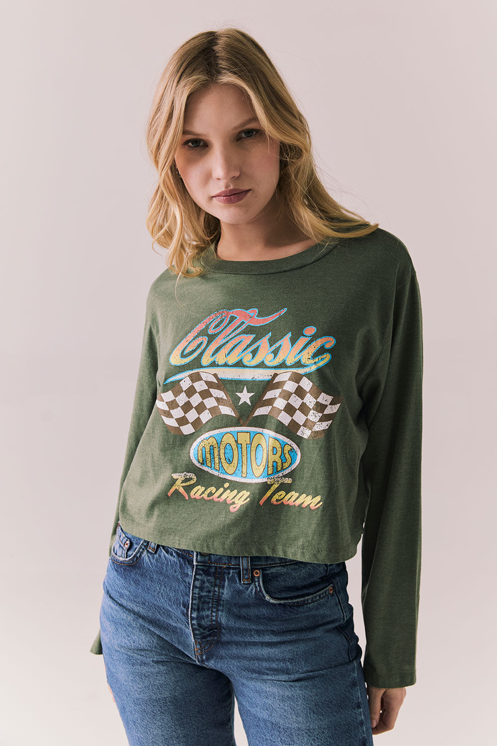 Front view of womens wearing Chaser's Classics Motors washed bronze green long sleeve with retro graphic on a plain background