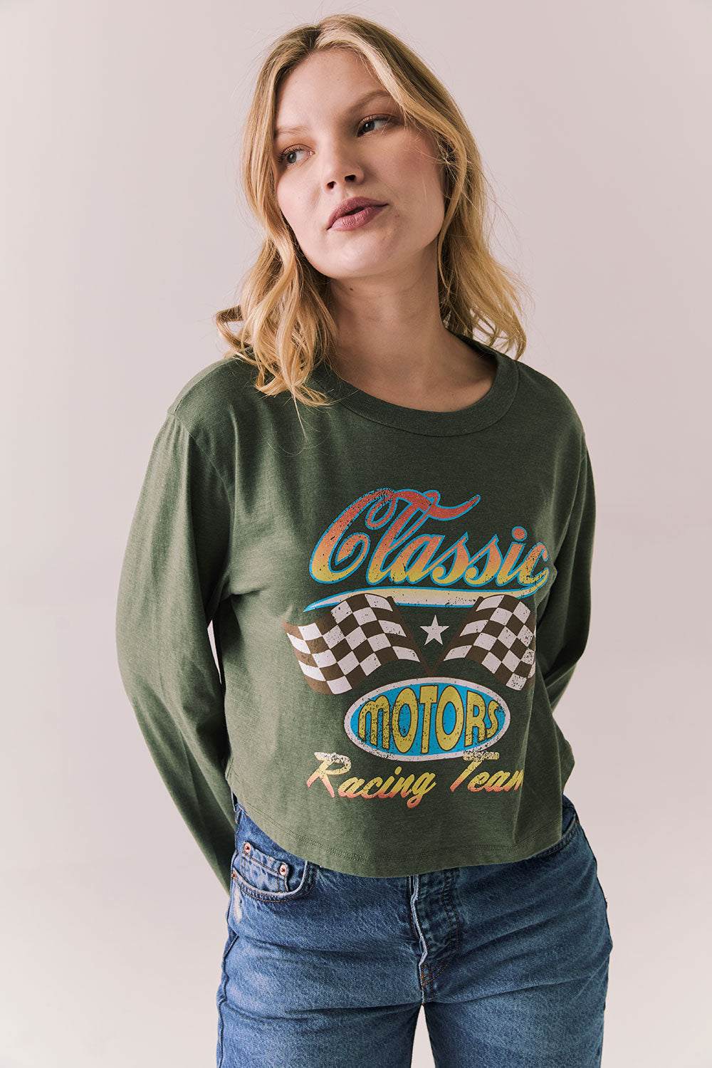 Front view of womens wearing Chaser's Classics Motors washed bronze green long sleeve with retro graphic on a plain background