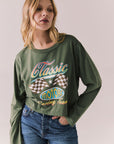 Front view of womens wearing Chaser's Classics Motors washed bronze green long sleeve with retro graphic on a plain background