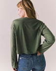 Back view of womens wearing Chaser's Classics Motors washed bronze green long sleeve with retro graphic on a plain background