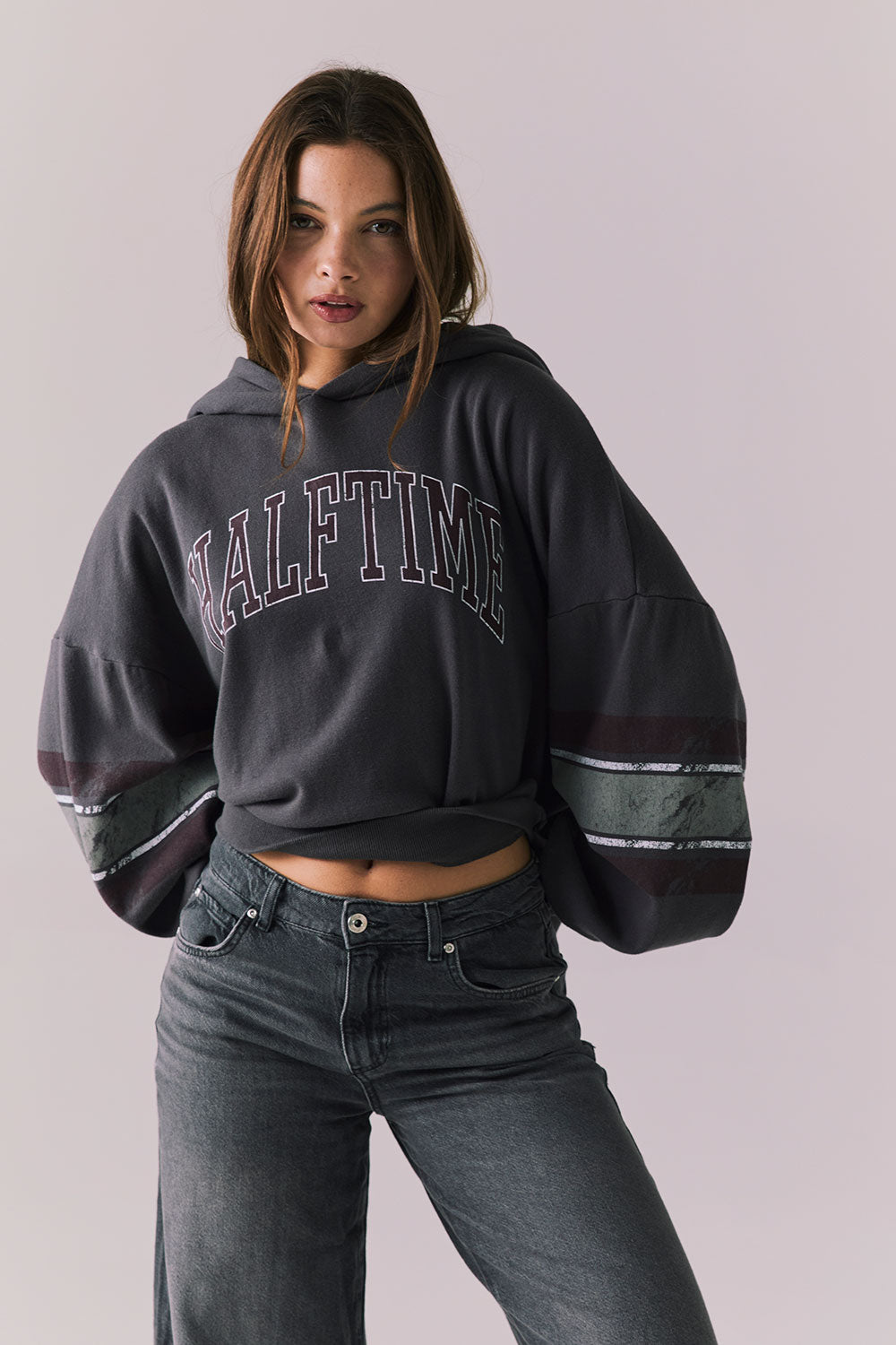 Front view of model wearing the Halftime fleece pullover hoodie in True Black with ‘HALFTIME’ chest graphic, against a plain background.