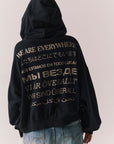 Back view of The Grateful Dead We Are Everywhere Hoodie in True Black with cropped boxy fit, hood up, and skull graphic made from stars and zodiac signs against a plain background