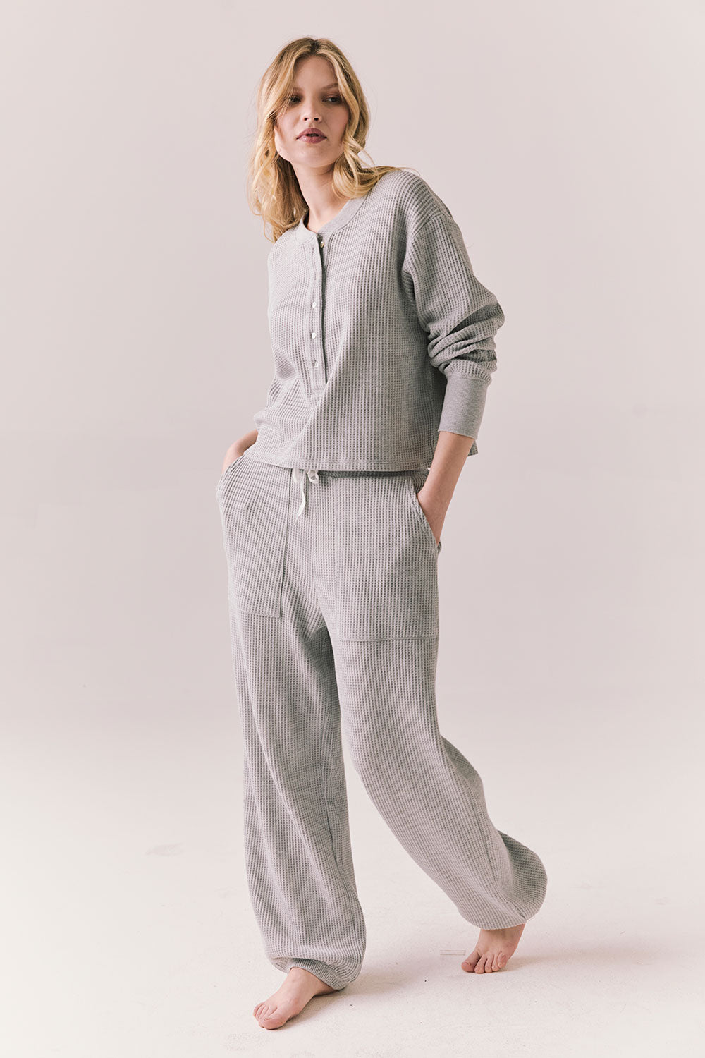 Side full view of Thayne cropped thermal henley top in Heather Grey with 3/4 button placket and ribbed texture and matching Billy Joggers against a plain background