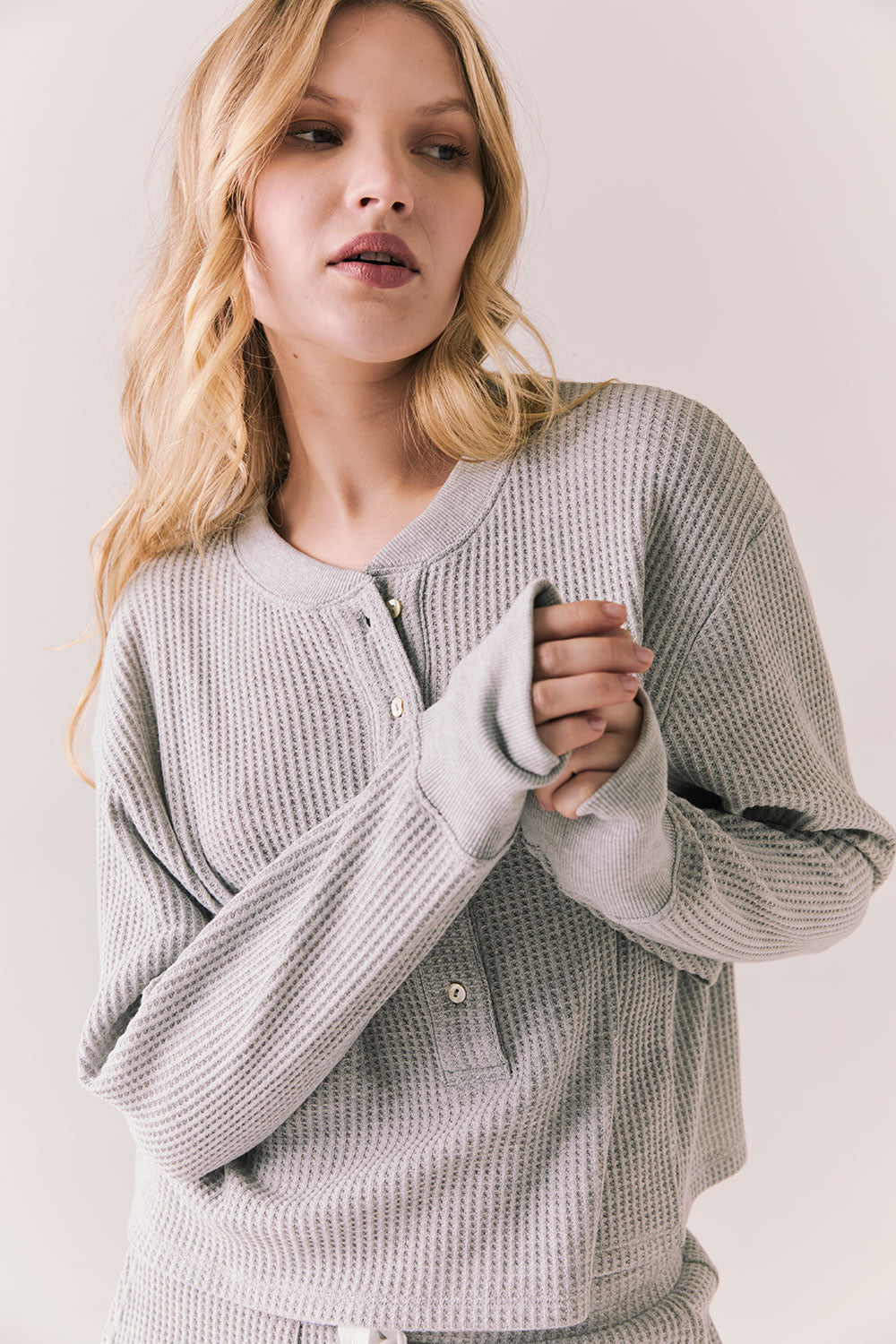 Front view of Thayne cropped thermal henley top in Heather Grey with 3/4 button placket and ribbed texture against a plain background