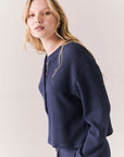 Side view of Thayne cropped thermal henley top in Midnight Blue with 3/4 button placket and ribbed texture against a plain background