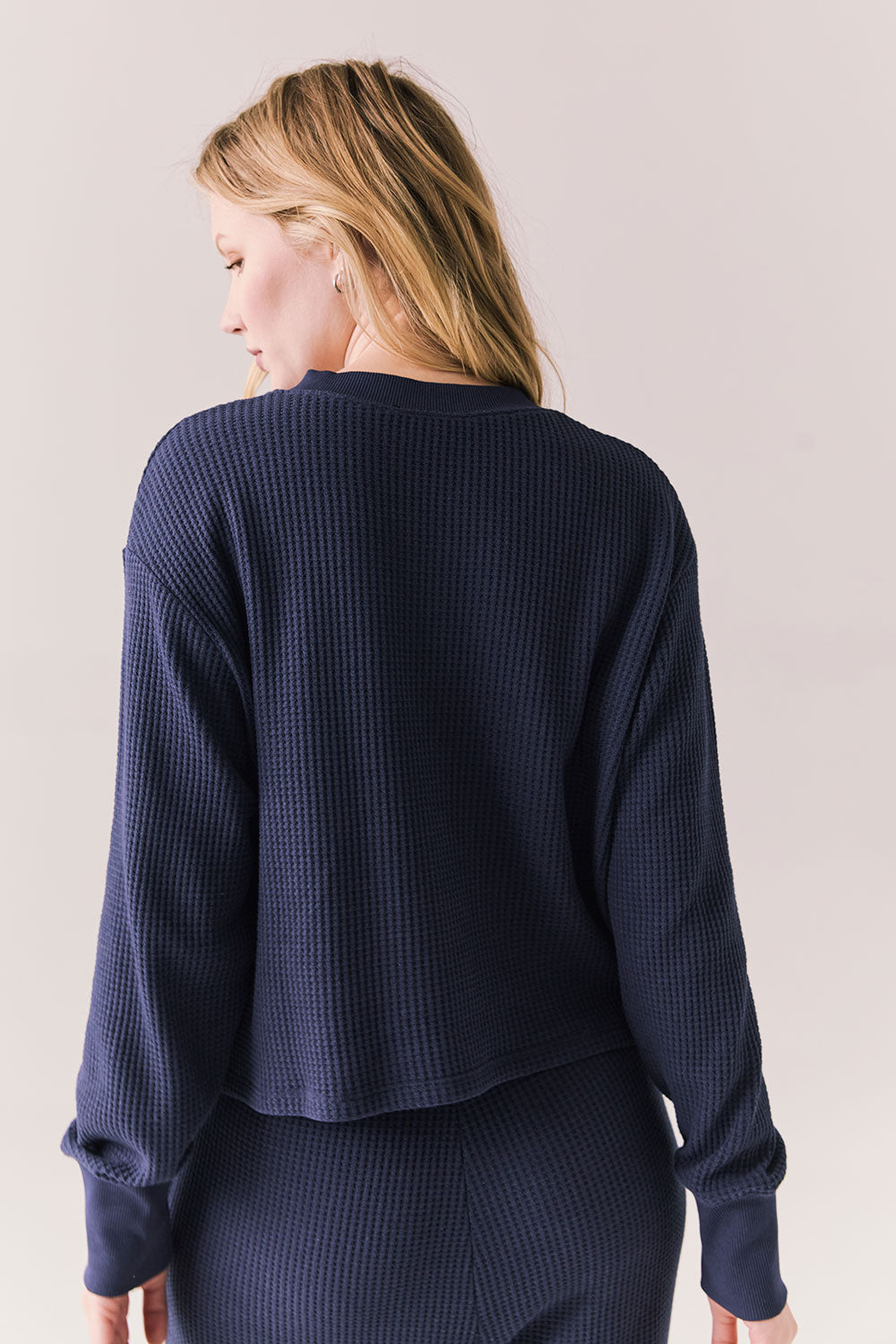 Back view of Thayne cropped thermal henley top in Midnight Blue with 3/4 button placket and ribbed texture against a plain background