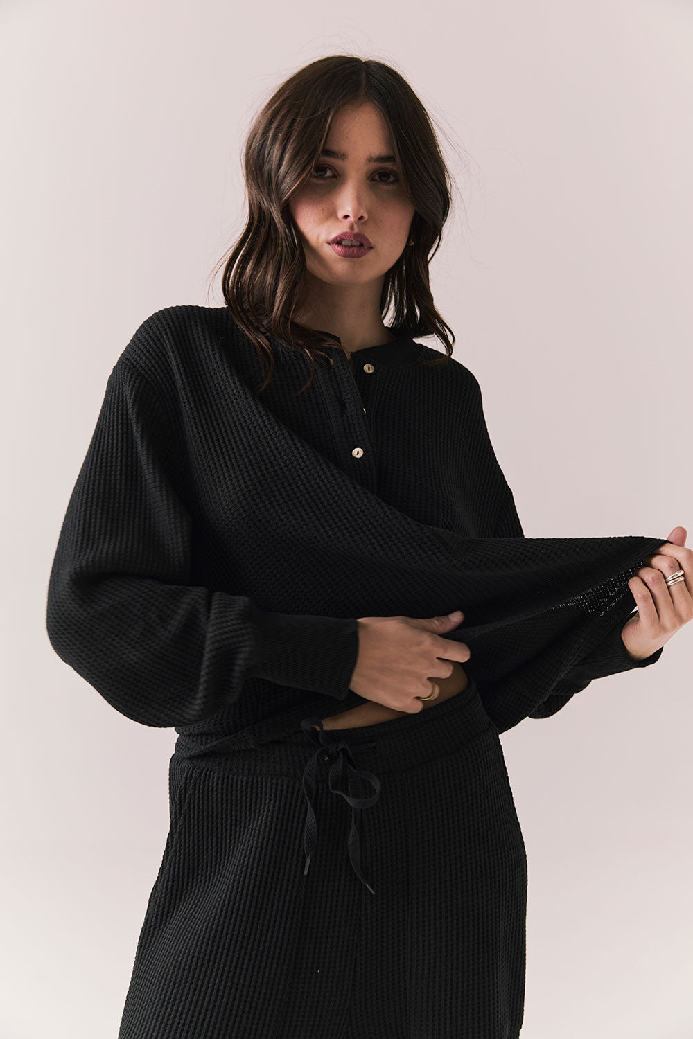Front view of Thayne Long Sleeve in True Black with cropped fit, henley placket, and ribbed texture against a plain background