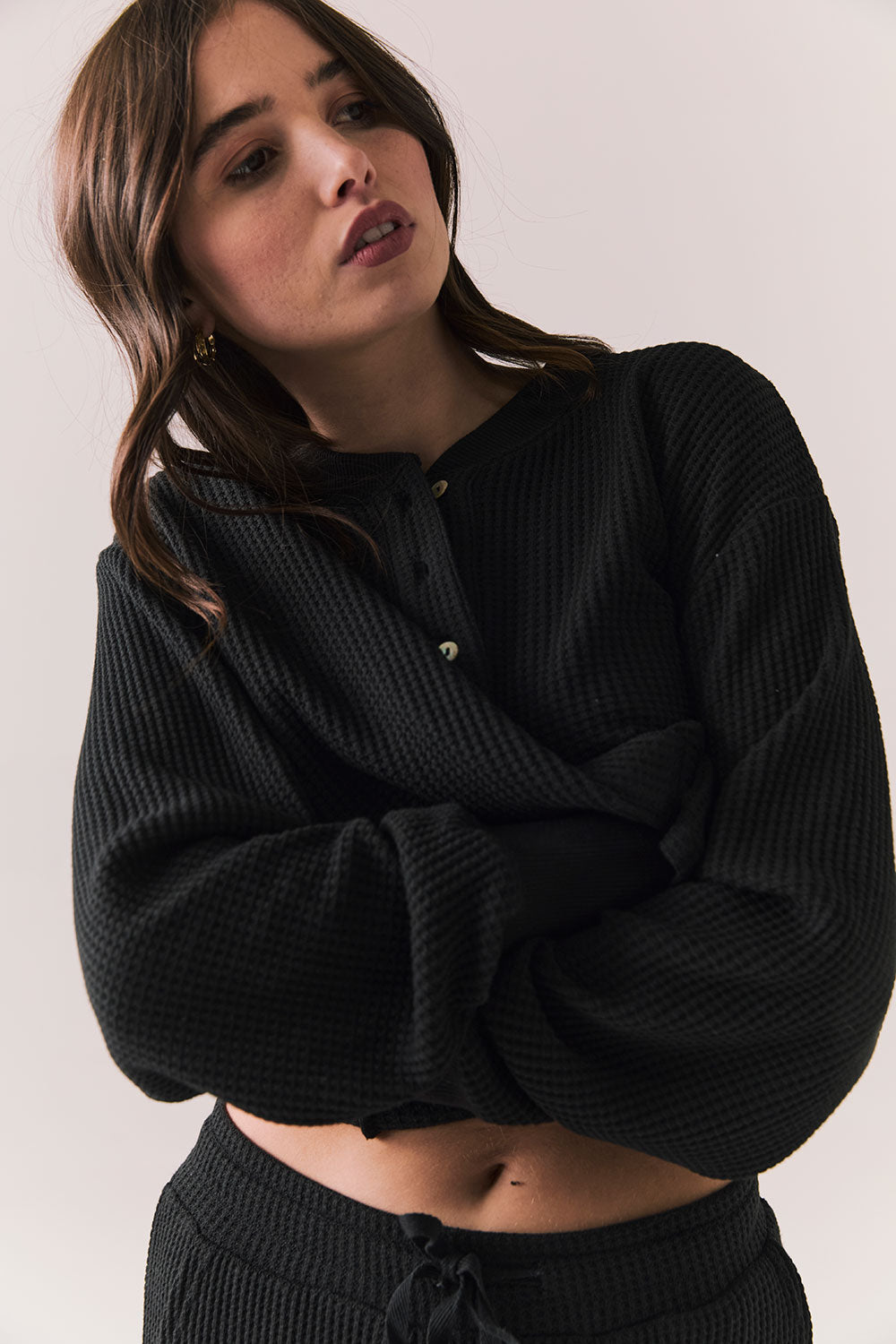 Front view of Thayne Long Sleeve in True Black with cropped fit, henley placket, and ribbed texture against a plain background