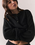 Front view of Thayne Long Sleeve in True Black with cropped fit, henley placket, and ribbed texture against a plain background