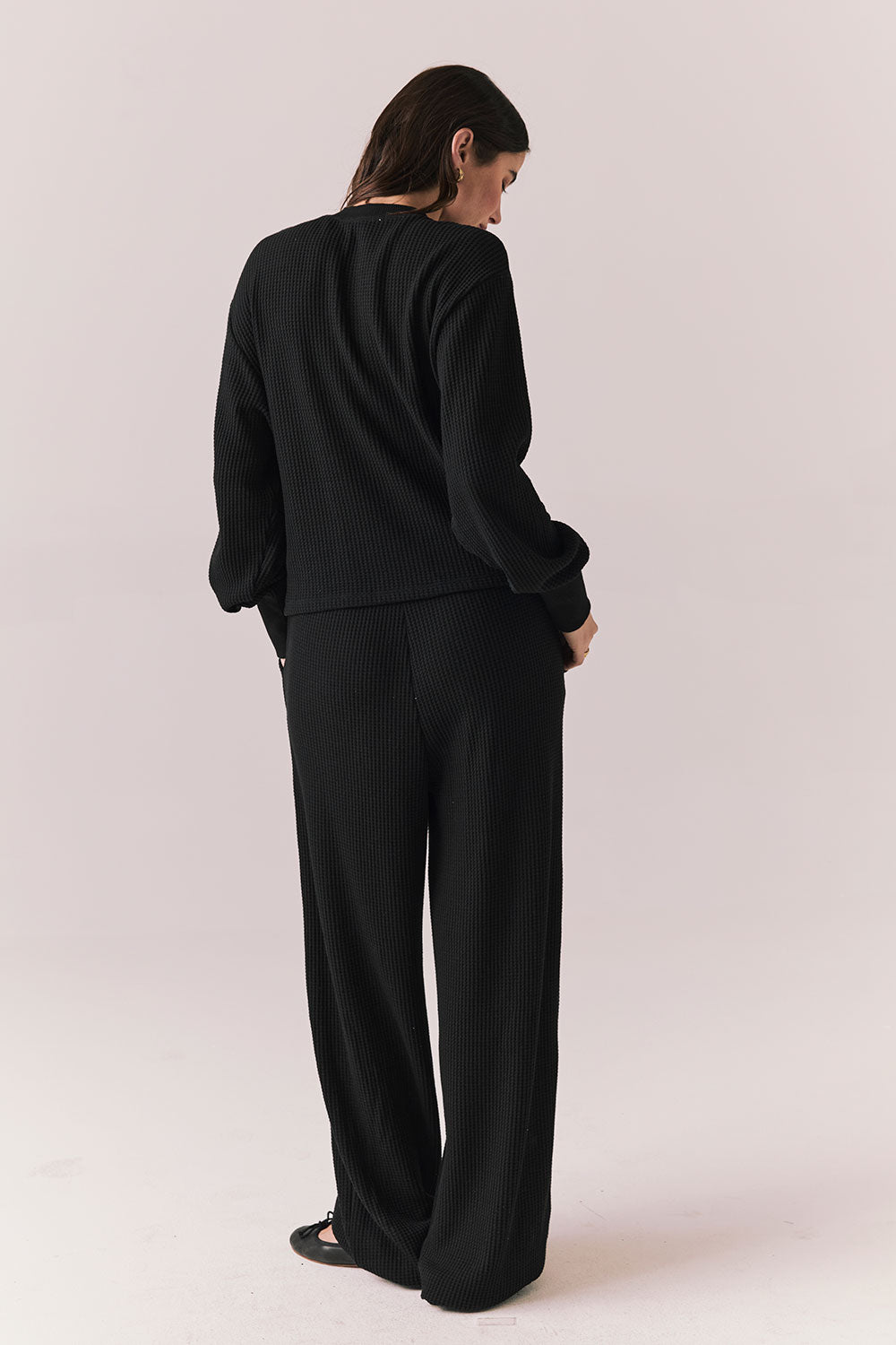 Back full body view of model wearing Thayne Long Sleeve in True Black with matching Billy Joggers against a plain background
