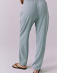 Back view of woman wearing Chaser's Mission Joggers in garden green sage on a plain background