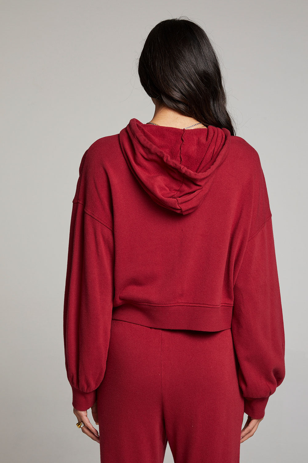Back view of model wearing Abilenee Blood Red Zip Up Hoodie with cropped hem and full-zip closure against a plain background
