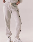 Front view of NYC Stars Joggers in Heather Grey with black star print down each leg, styled for a casual lounge look, against a plain background
