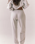 Back view of NYC Stars Joggers in Heather Grey with black star print down each leg, styled for a casual lounge look, against a plain background