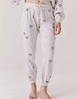 Front view of woman wearing Chaser’s light grey Tossed Hearts Pants with small heart patterns on a white background