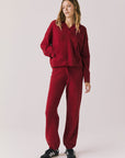 Full body view of woman wearing Chaser’s Hazen Purple-Red Fig Pullover Hoodie with matching Monica Purple-Red Fig Joggers on a white background