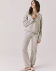 Full body view of woman wearing Chaser’s Hazen Heather Grey Pullover hoodie with matching Monica Heather Grey Joggers on a white background