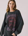 Front view of woman wearing Chaser’s Grateful Dead Disco Stealie Long Sleeve with a skull design on a plain background