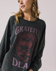Front view of woman wearing Chaser’s Grateful Dead Disco Stealie Long Sleeve with a skull design on a plain background