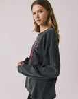 Side view of woman wearing Chaser’s Grateful Dead Disco Stealie Long Sleeve with a skull design on a plain background