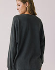 Back view of woman wearing Chaser’s Grateful Dead Disco Stealie Long Sleeve on a plain background