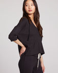 Side view of model wearing 3/4 Sleeve Split Side Licorice Dolman Hoodie in black showing relaxed fit and split-side detail on plain background