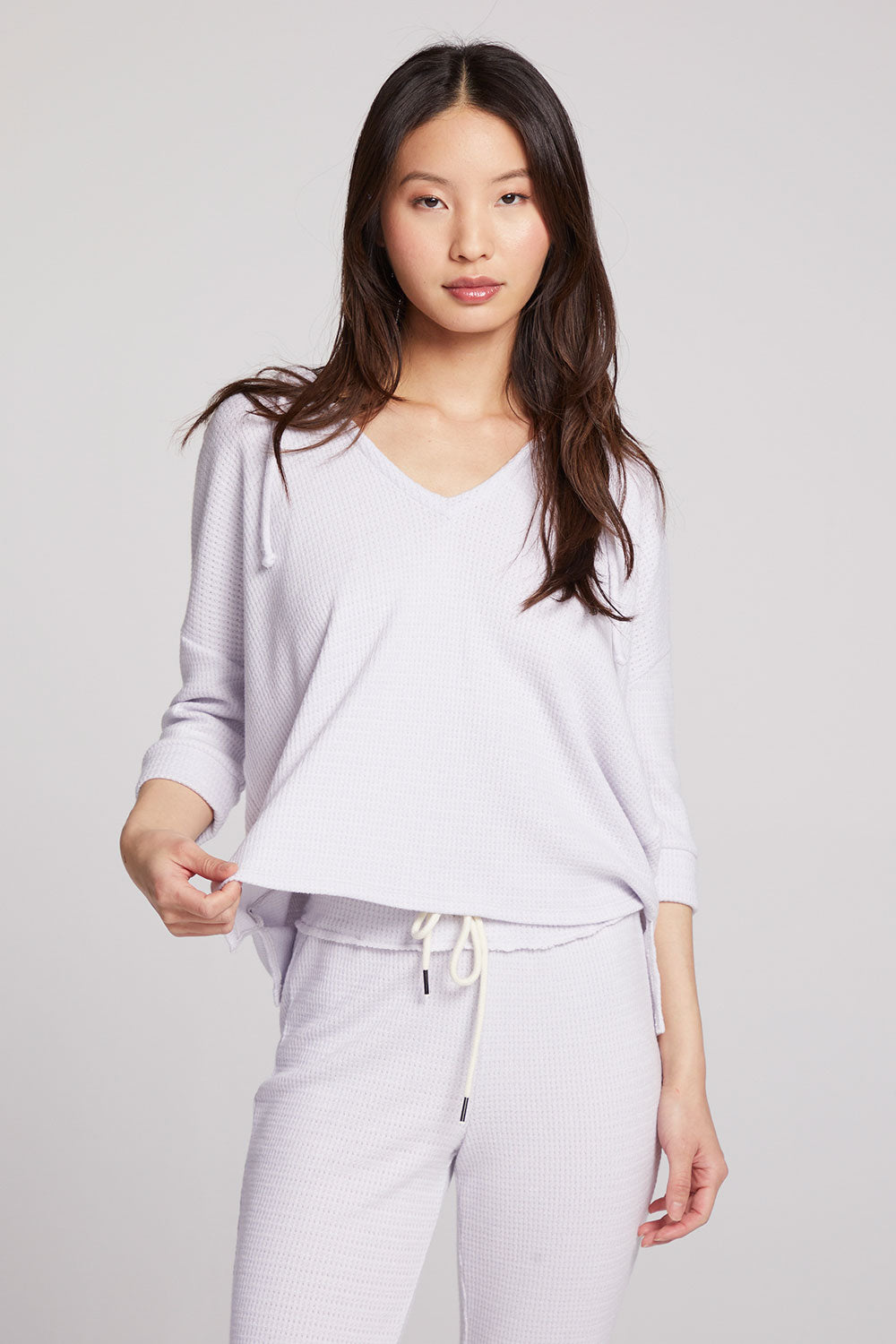 Front view of model wearing 3/4 Sleeve Split Side Light Heather Grey Dolman Hoodie with dolman sleeves and split-side hem on plain background with matching joggers