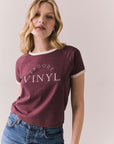Front view of model in J’adore Vinyl Tee in fig purple with cream ringer trim and vintage-style text