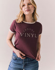Front view of model in J’adore Vinyl Tee in fig purple with cream ringer trim and vintage-style text