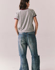 Back body view of model in Coca-Cola heather grey ringer tee and denim