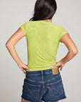 Back view of model wearing the 90’s Chartreuse Baby Tee in bright green with scoop neck and fitted cropped cut and cut off denim against a plain background