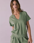 Model wearing the Chaser Cheyenne Meadow Green Pullover featuring a relaxed fit with a split neckline and raw-edge short sleeves