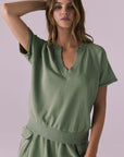 Model wearing the Chaser Cheyenne Meadow Green Pullover featuring a relaxed fit with a split neckline and raw-edge short sleeves