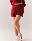 Crimson red drawstring lounge shorts in pillow terry fabric.