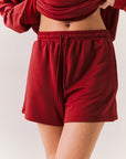 Crimson red drawstring lounge shorts in pillow terry fabric.
