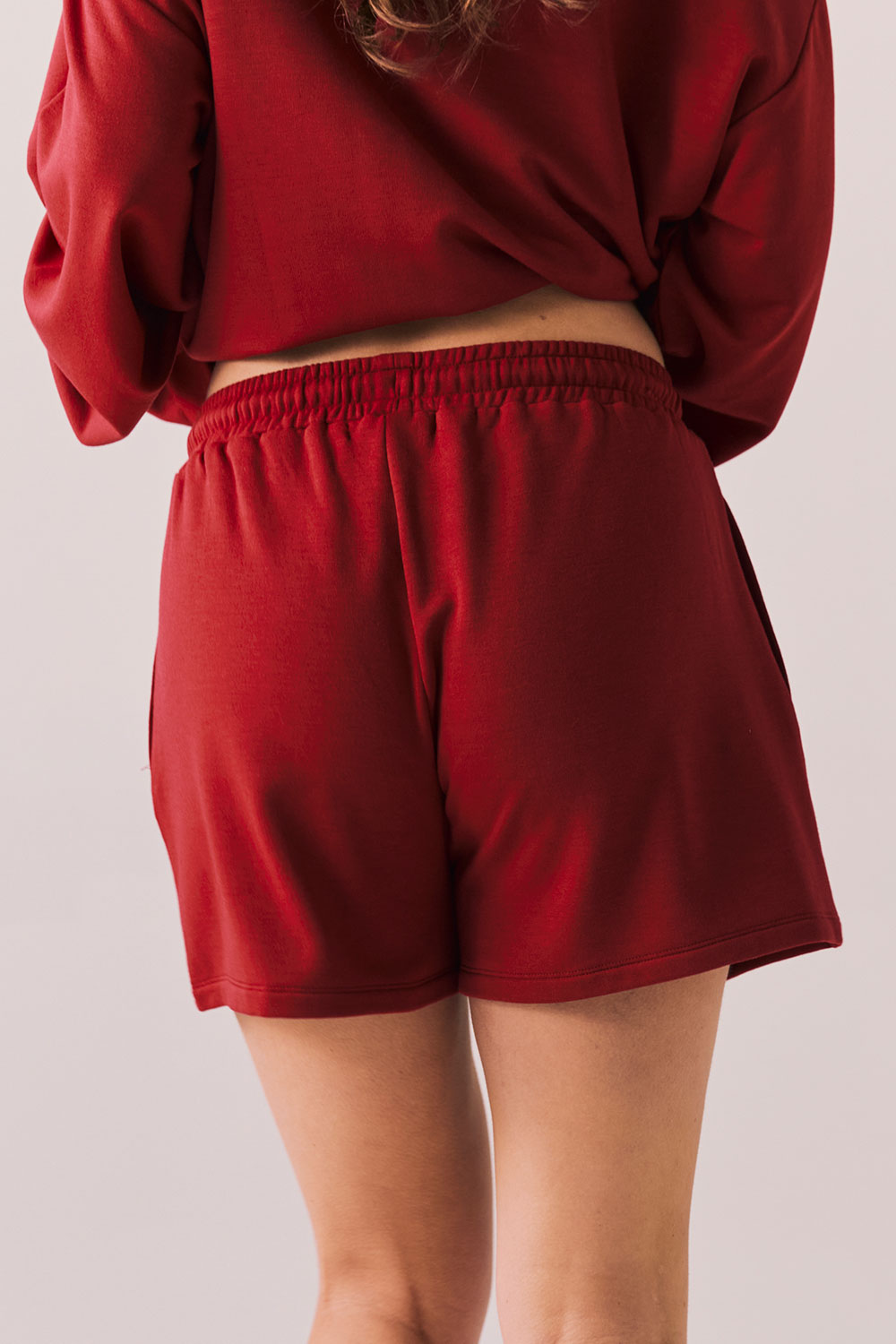Crimson red drawstring lounge shorts in pillow terry fabric.