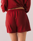 Crimson red drawstring lounge shorts in pillow terry fabric.