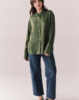 Full front view of a model wearing the Helenaa button-down shirt in bronze green with collared neckline and relaxed silhouette, styled with blue jeans, against a plain background.