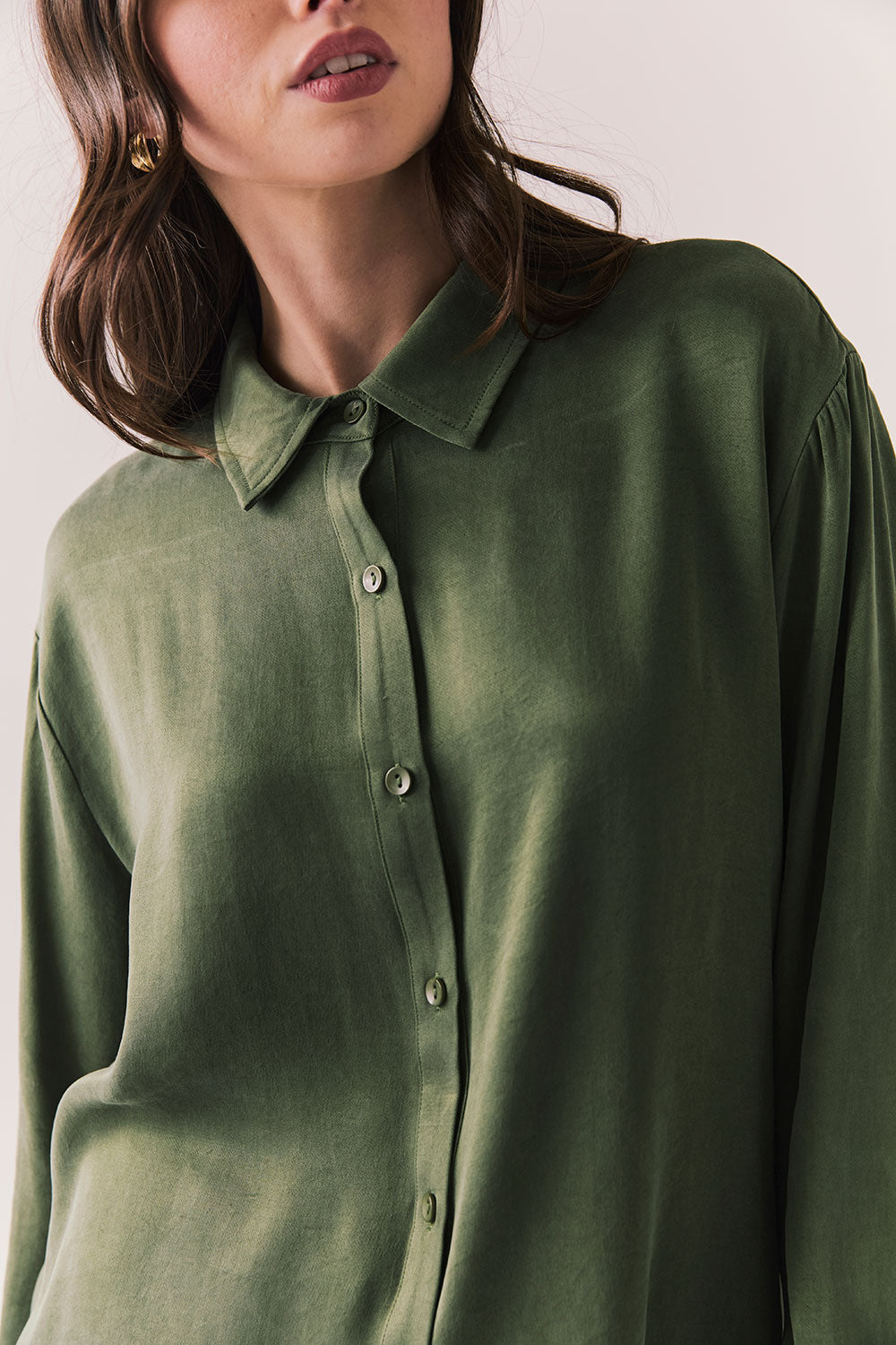 Front view of a model wearing the Helenaa button-down shirt in bronze green with collared neckline and relaxed silhouette, against a plain background.