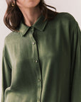 Front view of a model wearing the Helenaa button-down shirt in bronze green with collared neckline and relaxed silhouette, against a plain background.