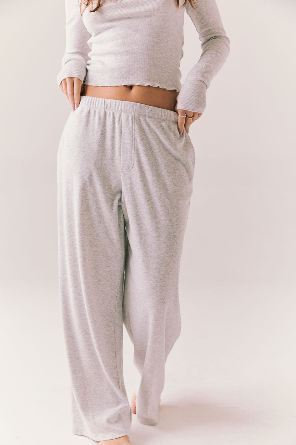 Light heather grey joggers with elastic waistband and relaxed fit, made from recycled fleece.