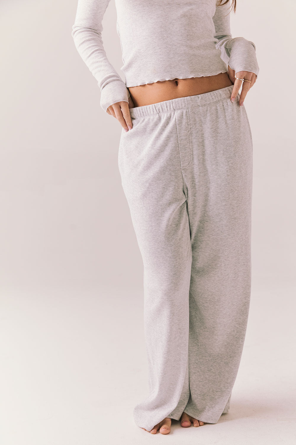 Light heather grey joggers with elastic waistband and relaxed fit, made from recycled fleece.