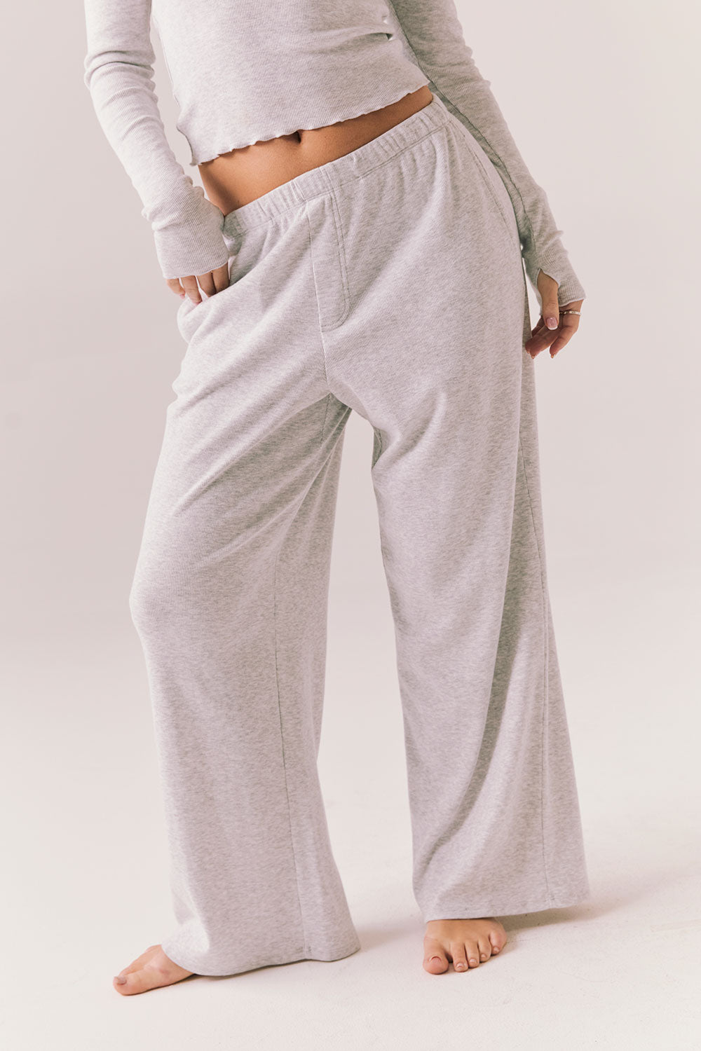 Light heather grey joggers with elastic waistband and relaxed fit, made from recycled fleece.